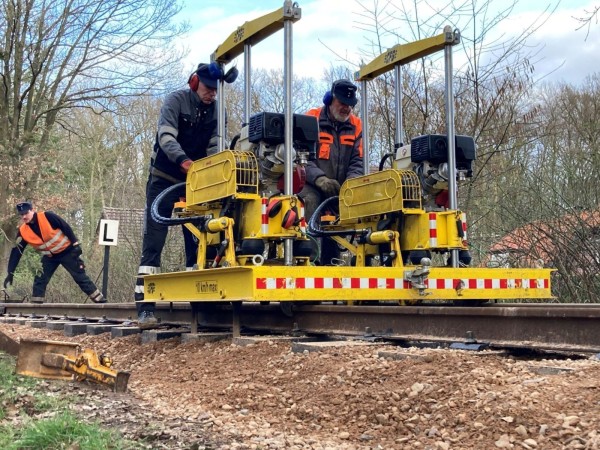 099 Die Stopfmaschine in Aktion, bedient von Klaus und Robert. <br />Erkennbar ist die nicht vorhandene Profilfreiheit zwischen Gleis und Maschine, als einziger Nachteil. Dies erfordert immer einen Transport auf dem Skl.<br />Hinter der Maschine sieht man, wie wenig  Kies nach dem Stopfgang noch vorhanden  ist.<br />Foto Jens B.