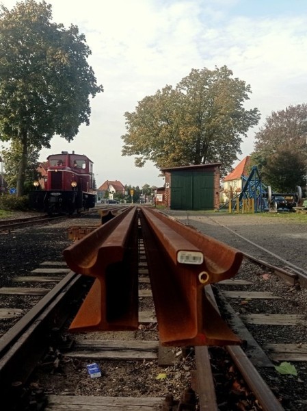 002<br />Mit der V3 geht´s bis Asendorf, wo wir die Drehschemelwagen 109 und 110 abholen. <br />Im Bf finden wir 45 Meter fabrikneue Rillenschienen auf Robelachsen verladen. <br />Rechts am Bildrand liegt das Gerüst der Rübenverladeanlage.