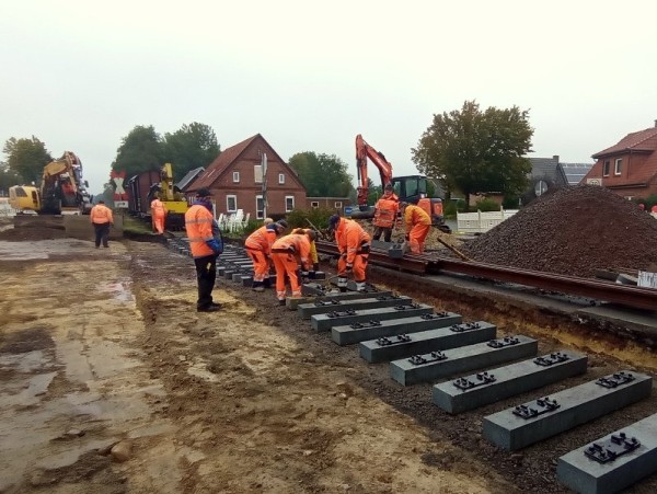 077<br />Nach dem Mittagessen ist es etwas trockener. Wir beginnen mit dem Aufbau des Gleises auf dem fertigen Planum.<br />Zwei Schwellenzangen und vier Mann, macht es für alle leichter. Wir verwenden hier den so genannten &quot;K-Oberbau&quot;.